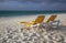 Two empty yellow lounge chairs on the beach