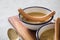 Two enamel bowls hearty German yellow split pea soup stew with wiener sausages on wooden board and light marble background