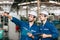 Two engineer worker working together with safety uniform and white helmet to work in industry checking production line