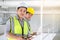 Two engineers man standing in the site. Engineer holding  tablet and smile under sunlight with copy space