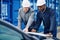 Two engineers standing in a commercial shipping yard discussing