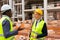 Two engineers standing on construction site and talking