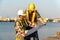 Two engineers stood wearing a safety helmet. Standing at the pier And holding the blueprint And consult the plan In the constructi