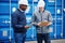 Two engineers tracking freight containers in a shipping yard