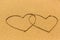 Two entangled hearts drawn out on a sandy beach. Love.