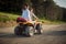 Two enthusiastic friends driving quad together