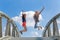 Two enthusiastic girls jumping on bridge