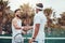 Two ethnic tennis players shaking hands before playing court game. Smiling athletes team standing and using hand gesture