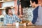 Two excited cheerful guys sitting, talking and laughing in cafe