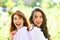 Two excited women friends girls posing on green nature background. People lifestyle concept.
