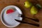 Two exotic fruits from Brazil called guava. A piece of cut fruit on a plate with fork and knife. Wood background