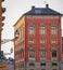 Two facades with windows reflecting the yellow sun