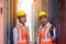 Two factory workers or engineers looking and pointing something in containers warehouse storage