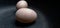 two fairly large duck eggs on a dark background