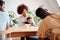 Two Families With Babies Meeting And Talking Around Table On Play Date At Home