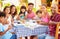 Two Families Eating Meal At Outdoor Restaurant Together