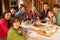 Two Families Enjoying Meal In Alpine Chalet