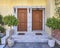 Two family house entrance solid wood doors and potted plants