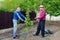 Two farmers discuss taking care of young pear tree in outdoor garden