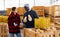 Two farmers discusses work issues, holding pumpkins