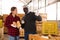 Two farmers discusses work issues, holding pumpkins