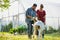 Two farmers, husband and wife tending to their goat on their farm