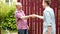 Two farmers shaking hands and talking to each other on sunny day