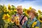 Two farmers with tablet examine their field with sunflowers