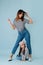 Two fashion lovers, mom and daughter wearing same clothes over blue background