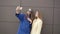 Two fashionable girls taking selfie in the coats 4K