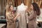 Two femail Dressmakers or tailors or fashiondesigners or seamstresses picking a tailor dummy mannequin in a lace cloth at own