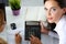 Two female accountants counting on calculator