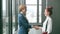 Two female advertising executives shaking hands