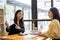 Two female Asian accountants discuss financial management planning. Analysis of new startup project ideas