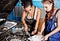 Two female auto mechanic repairing a car