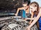 Two female auto mechanic repairing a car