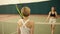 Two female competitors shake each others hands before starting playing tennis.