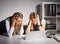 Two female coworkers looking at computer