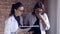 Two Female Doctors Look Through Medical Notes in a File and Consult on Diagnosis. Intelligent Professional Healthcare