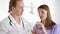 Two female doctors with tablet discussing new treatment at hospital room. Holding bottle of pills