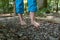 Two female feet are walking over pebbles