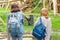 Two female friends with backpacks are watching at the zoo for a monkey. The concept of zoological