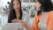 Two Female Friends In Coffee Shop Looking At Digital Tablet