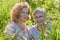 Two female friends having fun on nature. Chubby and slim middle-aged women pensioners in a green field