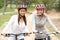 Two Female friends riding bikes in park