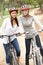 Two Female friends riding bikes in park