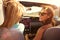 Two Female Friends On Road Trip Driving In Convertible Car