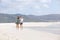 Two female friends walking on empty beach together