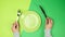 Two female hands hold a metal knife and fork, in the middle there is an empty round green plate