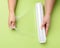 Two female hands hold a roll of transparent cling film for packaging products